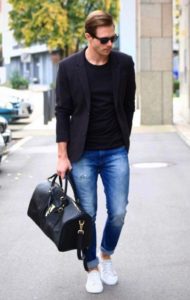 black blazer with black vest and blue jeans and white sneakers