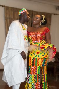 groom on plain agbada with kente cap matching the brides peplum dress - momoafrica